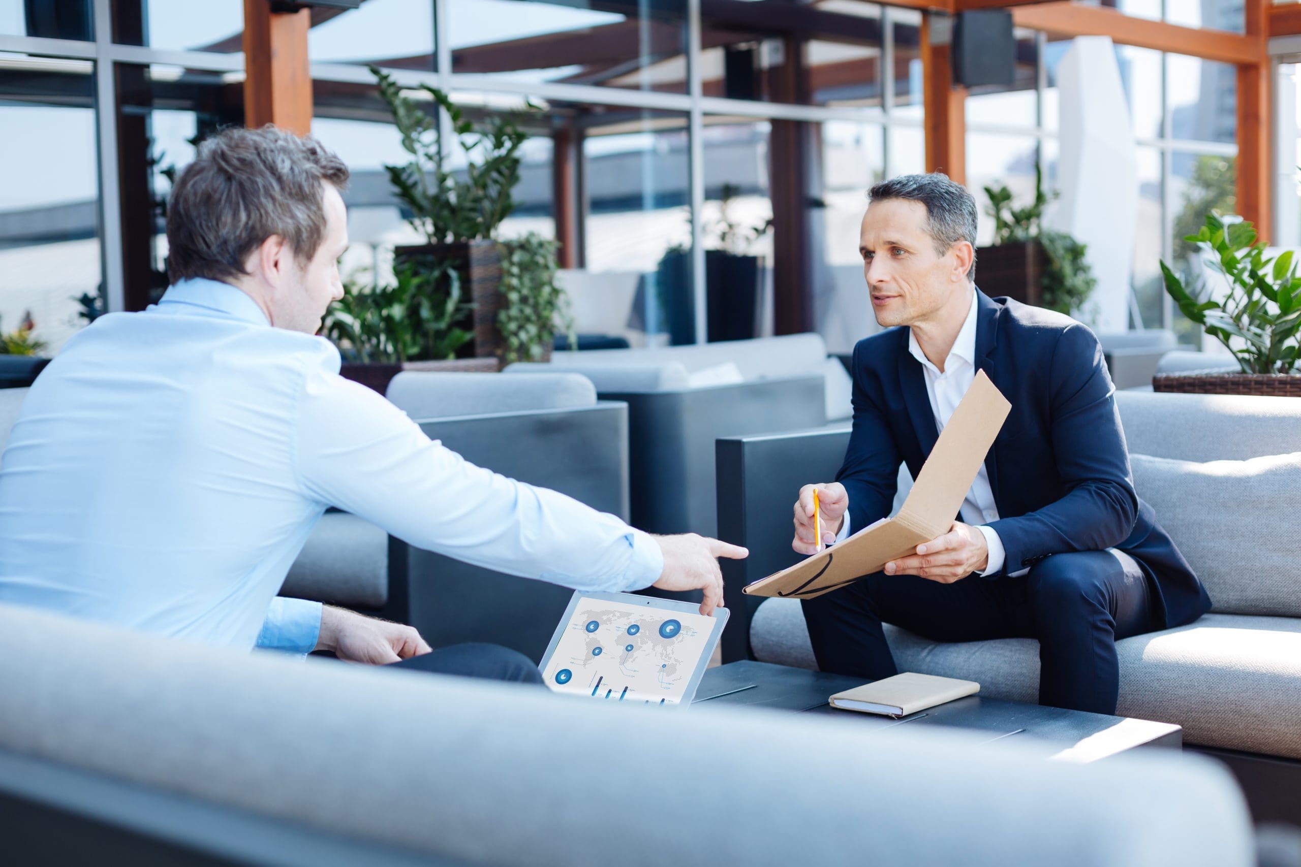 Pleasant smart businessman pointing at the folder